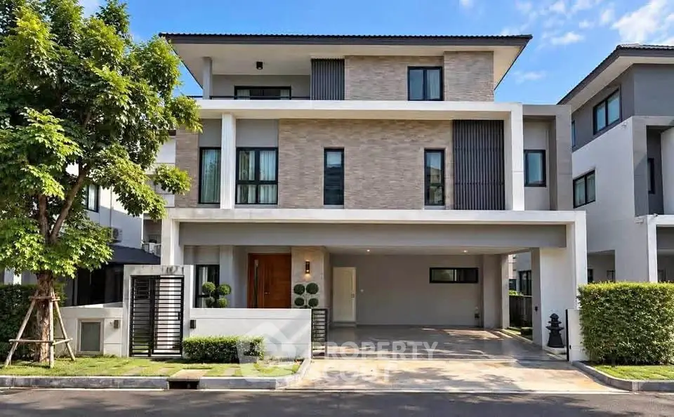 Modern three-story house with sleek design and spacious driveway in a suburban neighborhood.