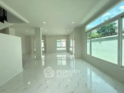 Spacious modern living room with large windows and marble flooring