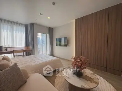 Modern bedroom with elegant decor, large windows, and a cozy seating area, perfect for relaxation and comfort.