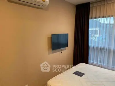 Cozy bedroom with wall-mounted TV and air conditioning, perfect for relaxation.