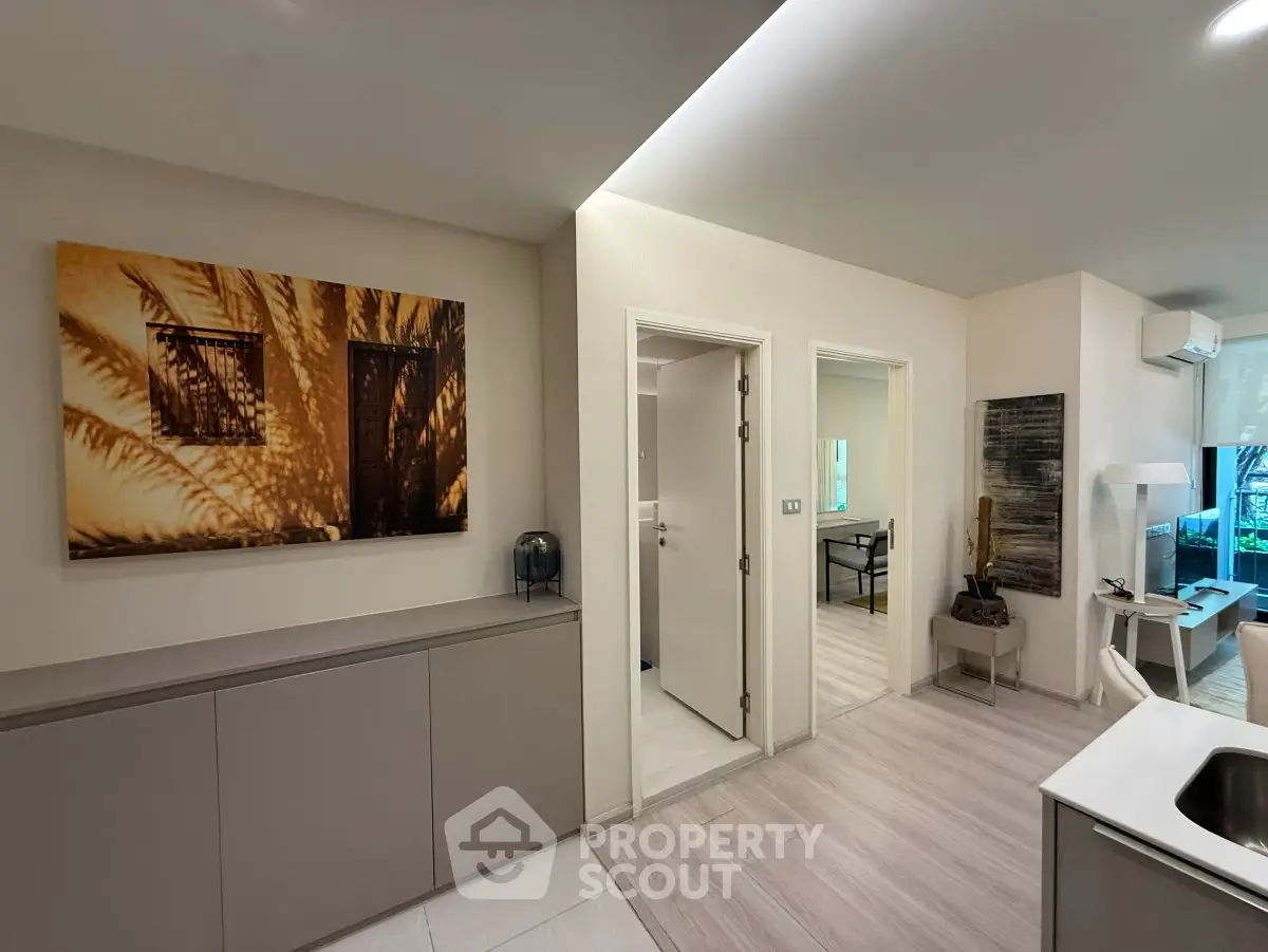Modern apartment interior with stylish decor and open layout, featuring a cozy living area and contemporary artwork.