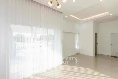 Spacious and bright living room with large windows and elegant lighting.