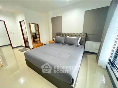 Spacious modern bedroom with elegant decor and ample natural light.