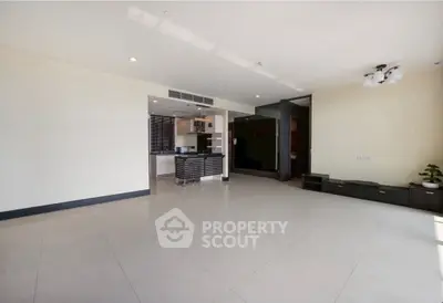Spacious modern living room with open kitchen and sleek tile flooring