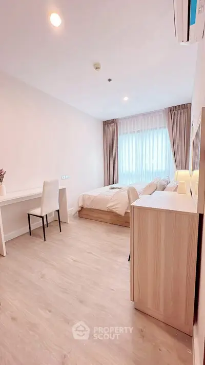 Modern bedroom with elegant decor and natural light, featuring a cozy bed and stylish furniture.