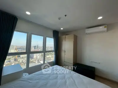 Modern bedroom with stunning city view from large windows, featuring sleek furniture and air conditioning.