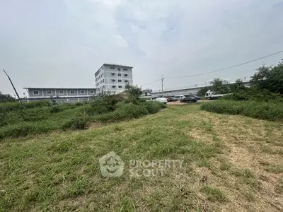 Spacious land plot with building and parking, ideal for development.
