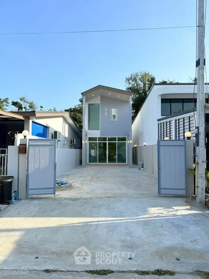 Modern two-story house with sleek design and spacious driveway in a serene neighborhood.