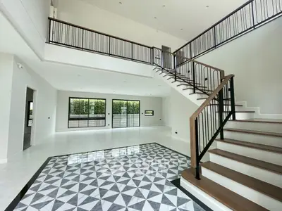 Spacious modern living room with elegant staircase and large windows