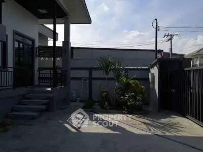 Spacious modern home exterior with garden and gated entrance, perfect for family living.