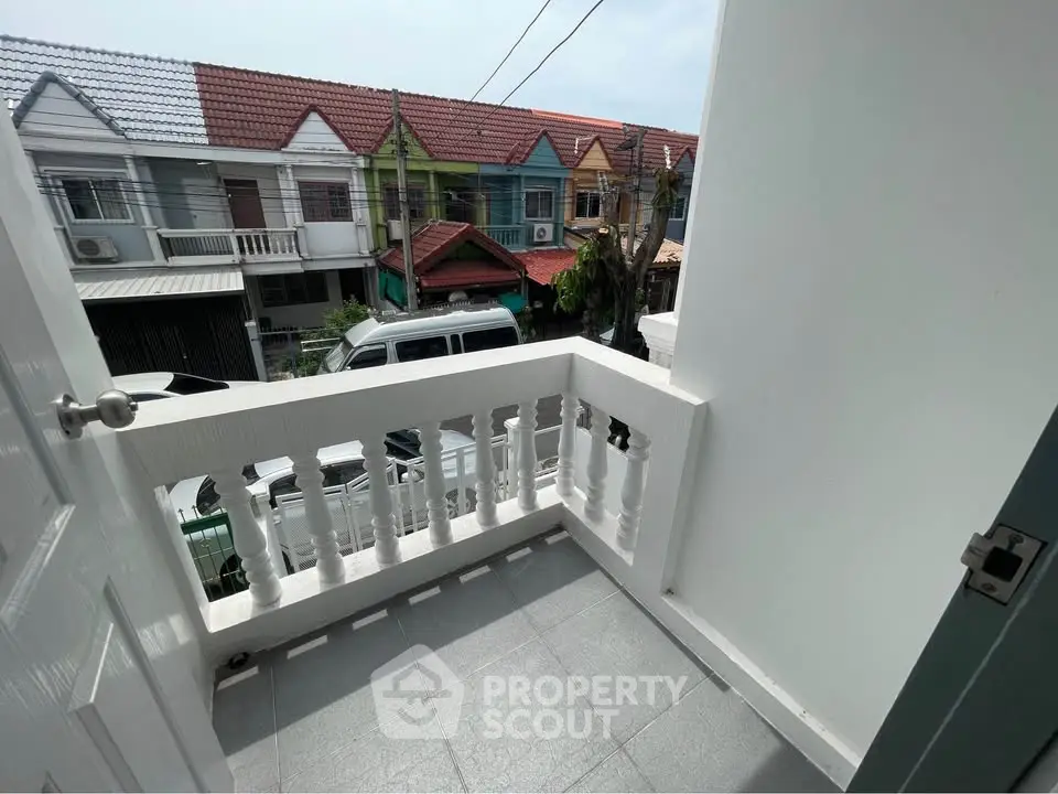 Charming balcony with street view in a vibrant neighborhood.