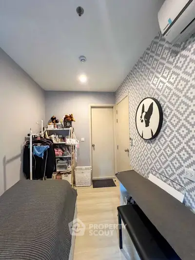Cozy bedroom with modern decor and air conditioning, featuring a stylish patterned wall and organized storage.