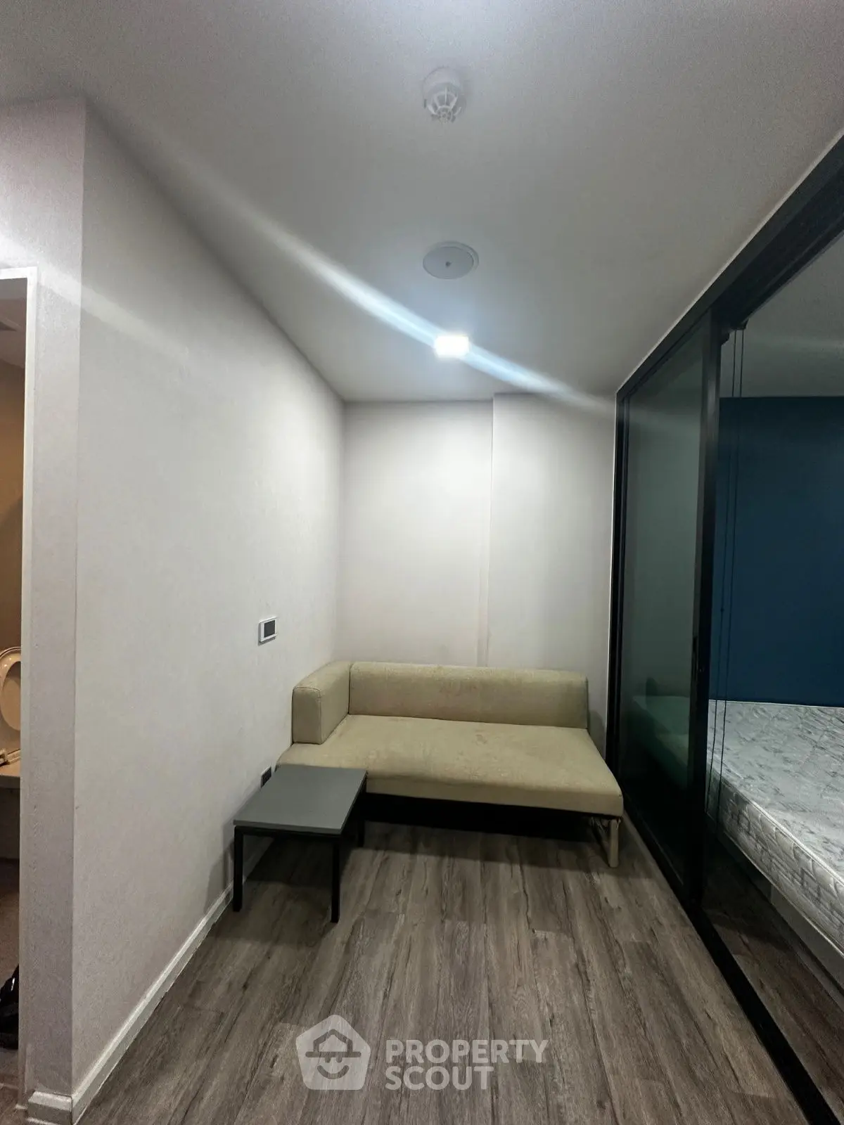 Cozy small living area with modern sofa and sliding glass doors in a contemporary apartment.