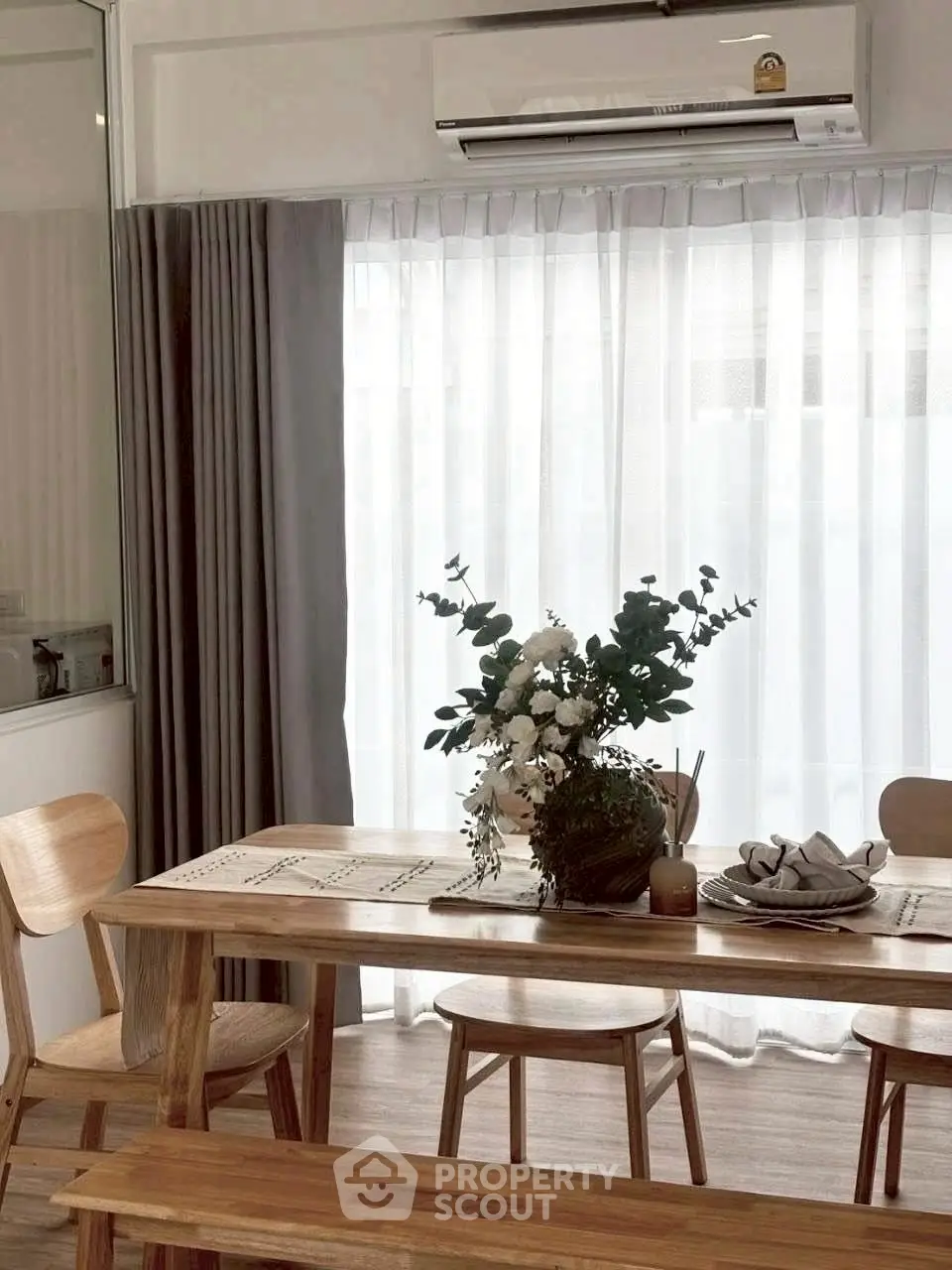 Chic dining area with wooden furniture and elegant floral centerpiece, perfect for modern living.