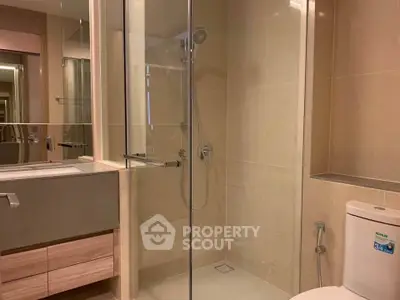 Modern bathroom with glass shower and sleek fixtures in a contemporary apartment.