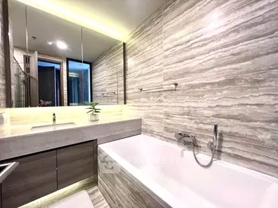 Luxurious modern bathroom with elegant marble tiles and sleek bathtub design.