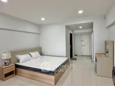Spacious bedroom with modern furnishings and sleek design in a contemporary apartment.