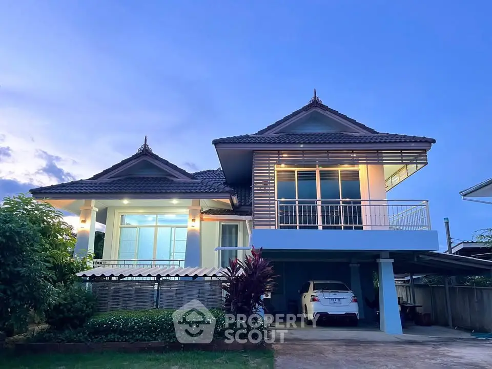 Stunning two-story house with modern architecture and spacious carport at dusk.