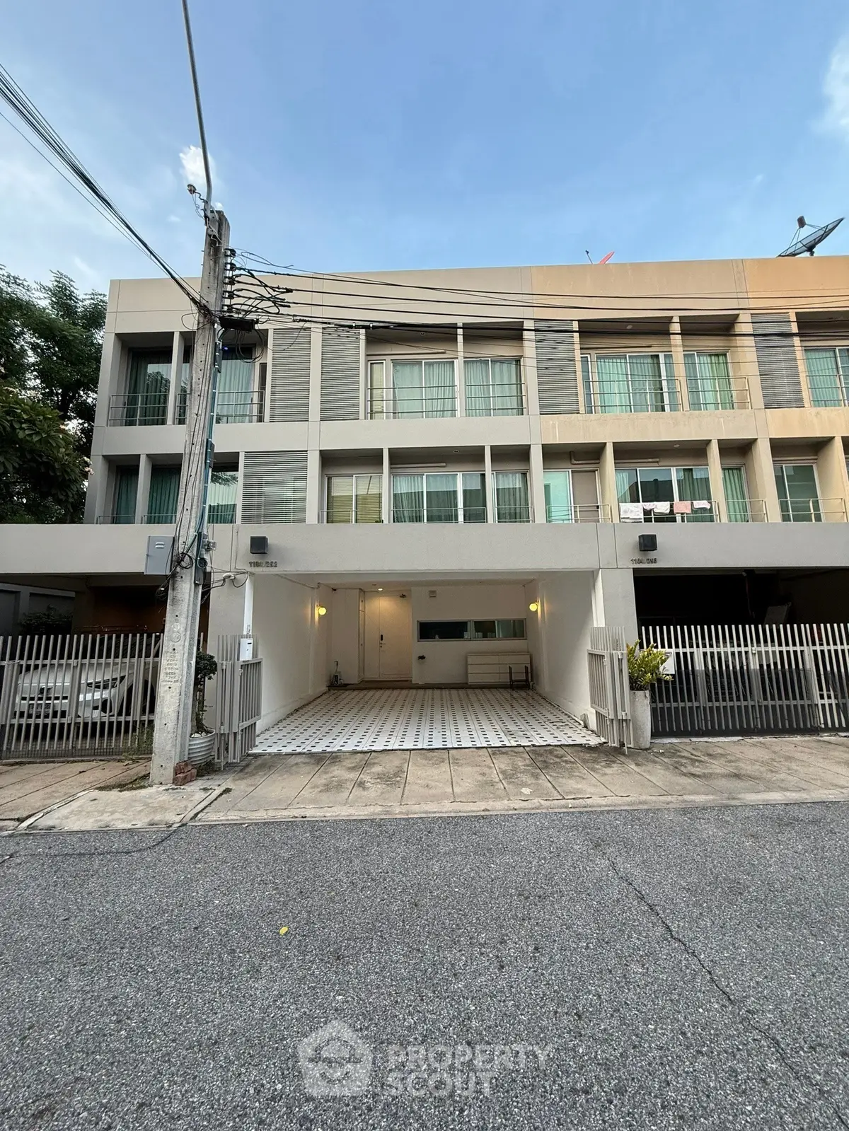 Modern townhouse exterior with gated parking and contemporary design.