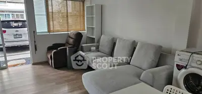 Cozy living room with modern furniture and washing machine, perfect for urban living.