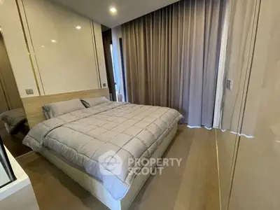 Modern bedroom with elegant design and cozy ambiance, featuring a plush bed and floor-to-ceiling curtains.