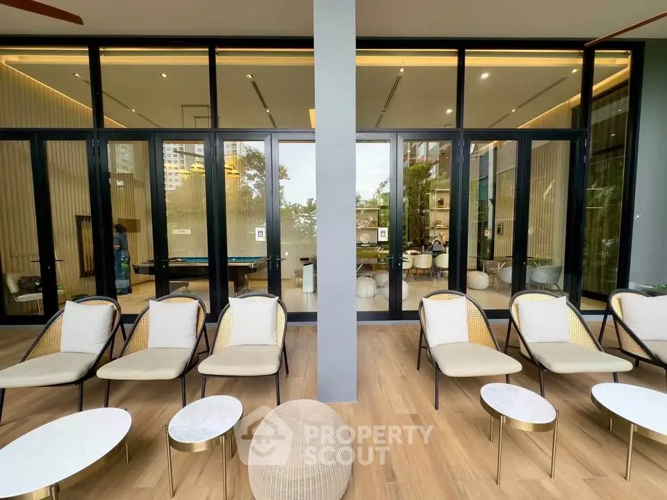 Luxurious modern lounge area with stylish seating and floor-to-ceiling windows in a high-end building.