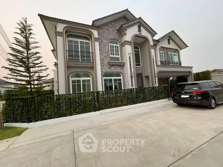 Elegant two-story house with stone facade and spacious driveway