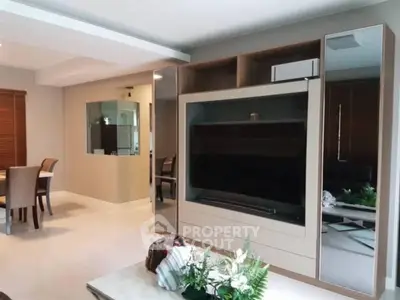Modern living room with sleek entertainment center and dining area, perfect for stylish urban living.