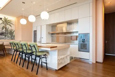 Luxurious modern kitchen with sleek design and high-end appliances, featuring an open layout and stylish bar seating.