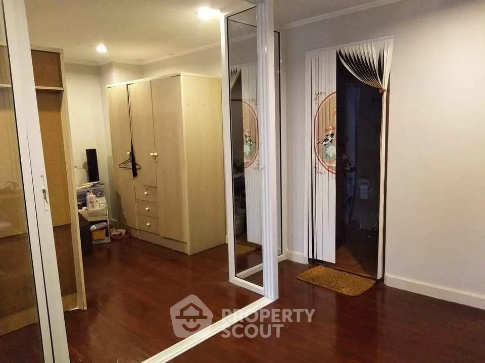 Spacious bedroom with wooden flooring and mirrored closet doors