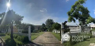 Spacious garden entrance with lush greenery and clear blue sky