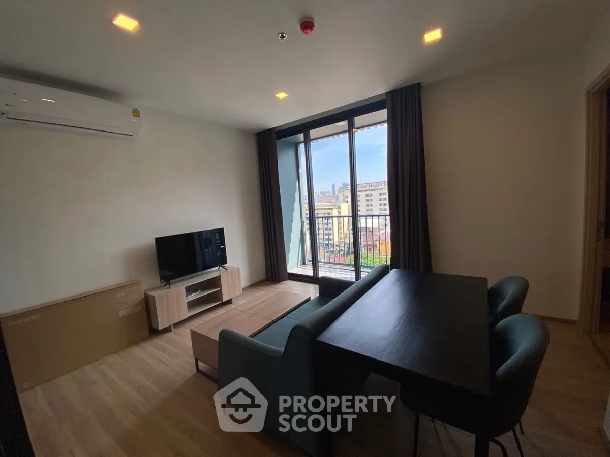 Modern living room with balcony view, stylish furniture, and natural light.