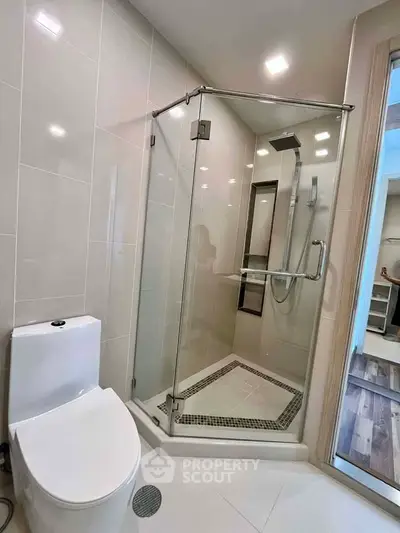 Modern bathroom with glass shower enclosure and sleek fixtures