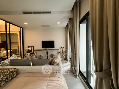 Modern living room with elegant decor and large windows opening to a balcony.