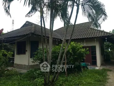 Charming rustic house with lush greenery and traditional roof design, perfect for nature lovers seeking tranquility.