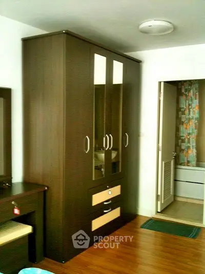 Modern bedroom with sleek wardrobe and wooden flooring