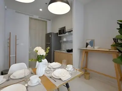 Modern kitchen with dining area, featuring sleek cabinetry and elegant table setting.