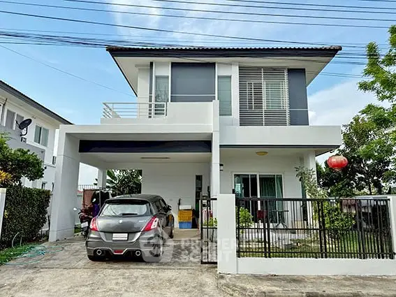 Modern two-story house with carport and garden in a suburban neighborhood.