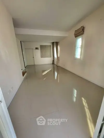 Spacious empty room with large windows and tiled flooring, perfect for customization.