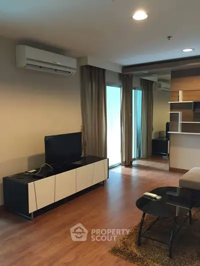 Modern living room with sleek furniture and wooden flooring in a stylish apartment.