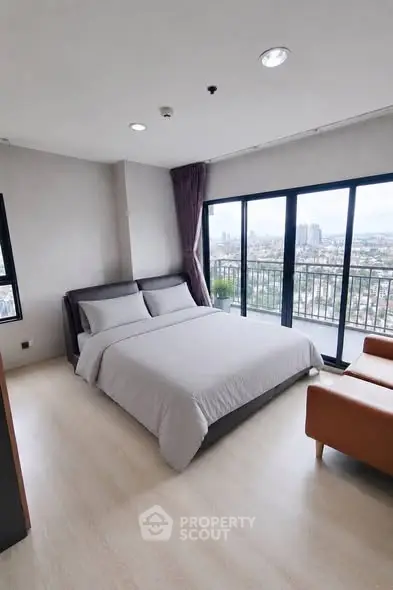 Spacious bedroom with city view and large windows in modern apartment