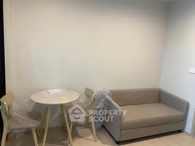 Cozy living room with modern sofa and dining set, perfect for small apartments.