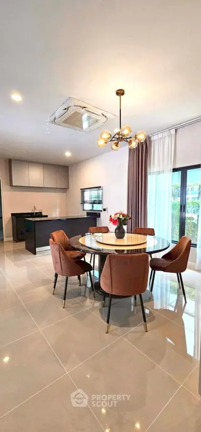 Modern dining area with elegant lighting and open kitchen layout in a stylish apartment.
