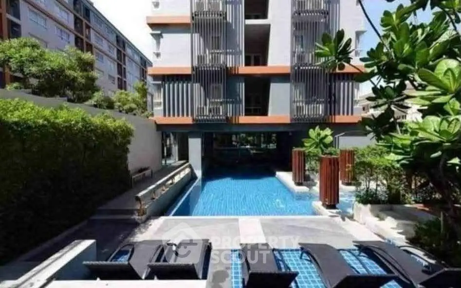 Luxurious condominium with modern pool and lush greenery, perfect for relaxation and leisure.