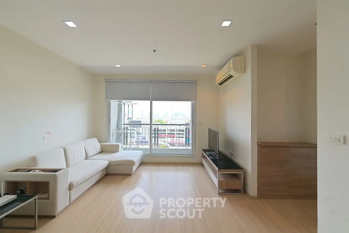 Modern living room with city view, featuring sleek furniture and minimalist design.