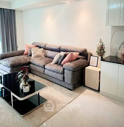 Modern living room with plush gray sofa, stylish coffee table, and elegant decor accents.