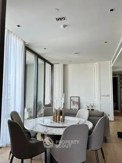 Elegant dining area with modern decor and large windows in a luxury apartment.
