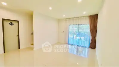 Spacious living room with large window and elegant curtains in modern home.