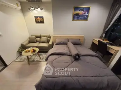 Cozy bedroom with modern decor, featuring a comfortable bed, stylish sofa, and a work desk by the window.