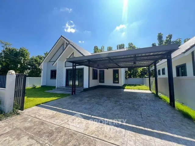 Charming modern house with spacious driveway and lush greenery under clear blue sky.